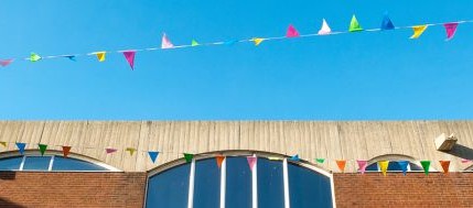 Colourful bunting flying over Falmer House, home of the Doctoral School at Sussex