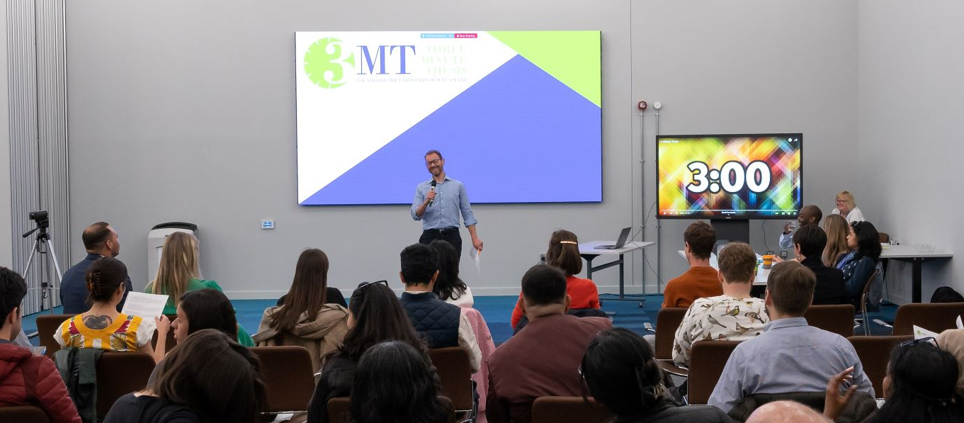 Prof Jeremy Niven addresses the 3MT audience at the start of the event. A 3 minute timer is displayed on a large screen behind him. Image: Stuart Robinson